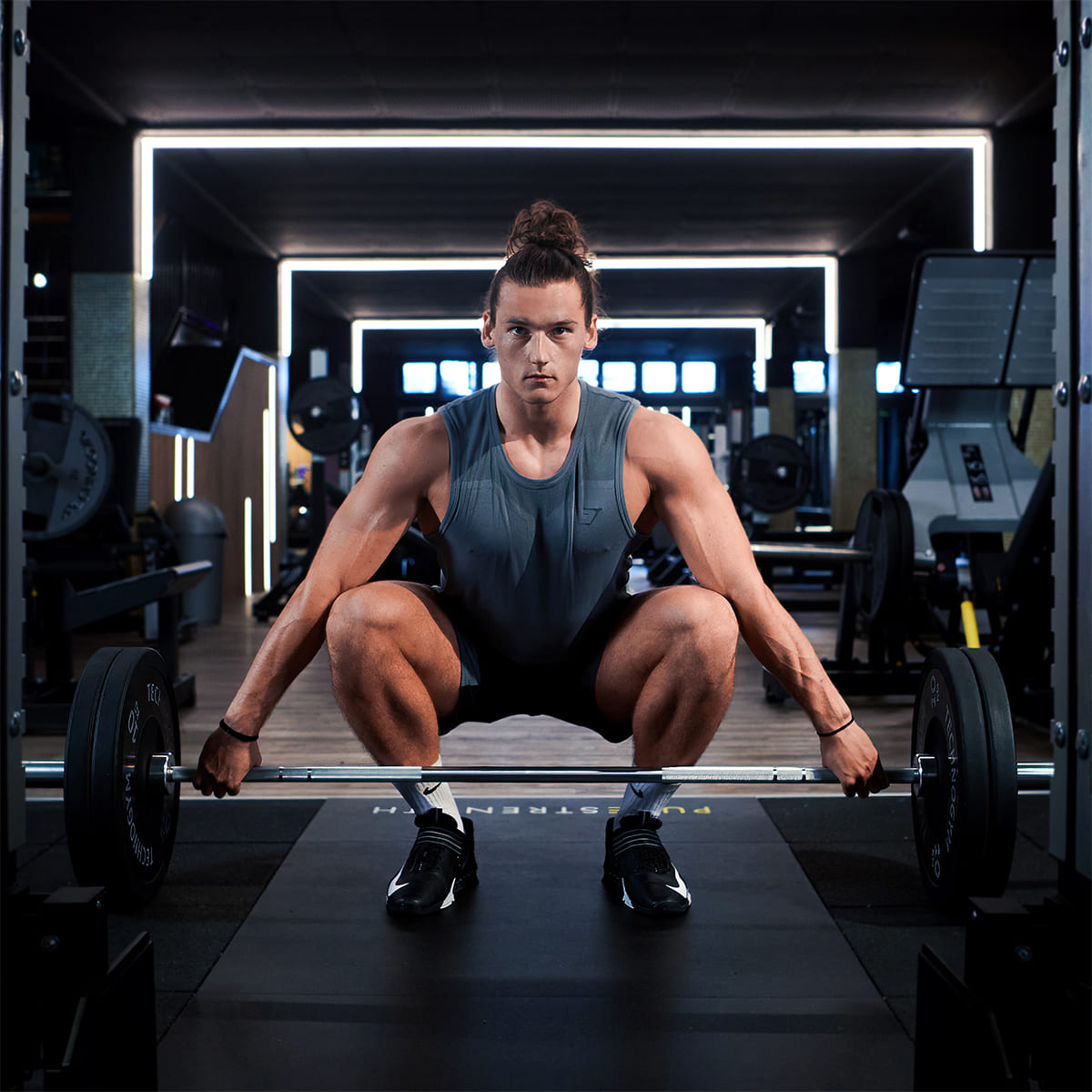 Junger Mann beim Langhanteltraining im Fitnessstudio